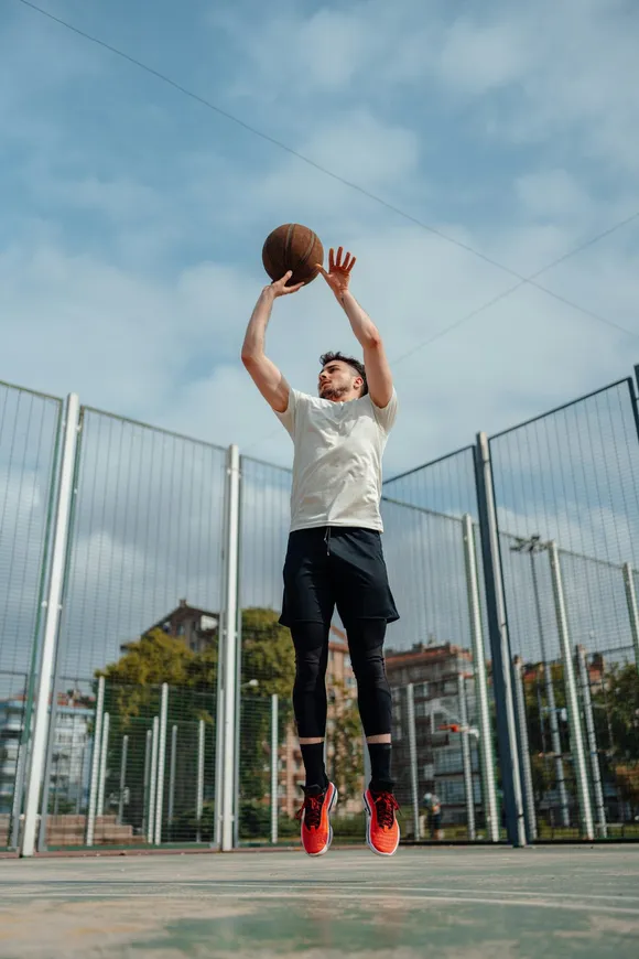 A player shooting on an outdoor court.
