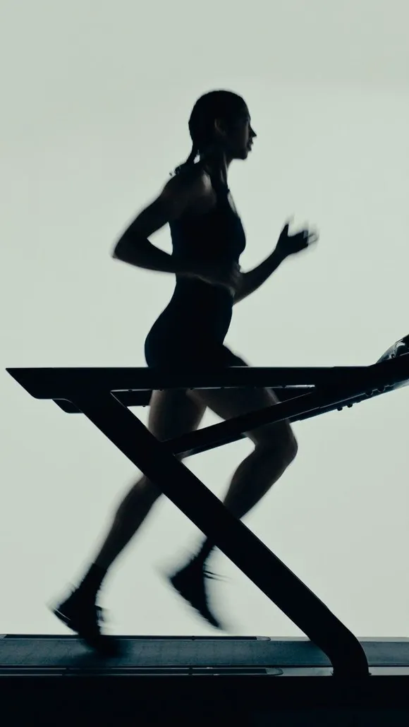 A runner silhouetted on a treadmill.